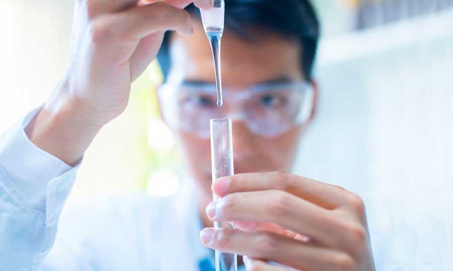 Technician looking at test tube